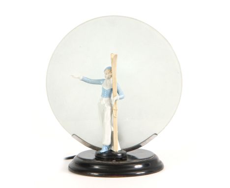 A 1930'S ART DECO CONTINENTAL LAMP mounted with a porcelain figure of a skier having a circular frosted glass shade  27cm hig