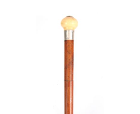 A 19TH CENTURY MALACA AND IVORY SWORD STICK with tapering cane shaft and carved ivory pommel with silver collar stamped 0.800