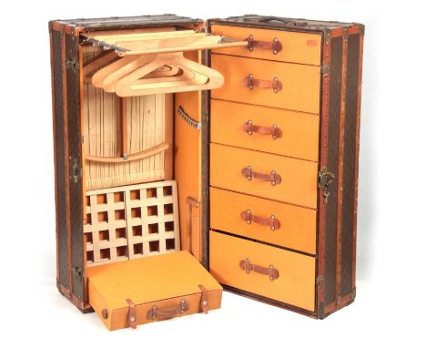 A 1920'S LOUIS VUITTON MONOGRAMMED BROWN LEATHER WARDROBE TRUNK with studded slatted bindings, brass straps and corner mounts