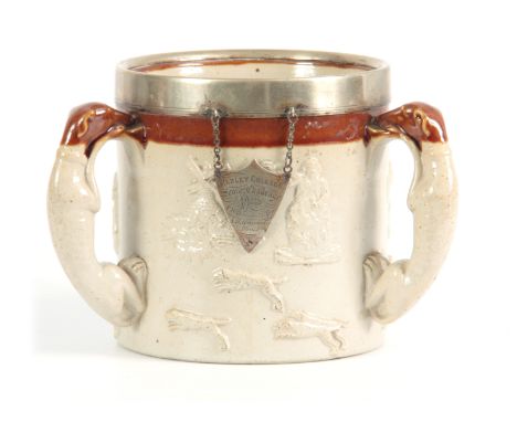 AN OVERSIZED DERBYSHIRE SALT GLAZED STONEWARE HUNTING TYG  the buff  ground with a wide treacle glazed border and nickel moun
