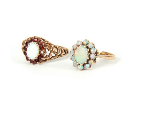 TWO LADIES 9CT GOLD AND OPAL RINGS both set with oval opals, one surrounded by smaller opals, the other surrounded by rubies,