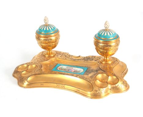 A 19TH CENTURY SERVES PORCELAIN MOUNTED ORMOLU INKWELL / DESK STAND inset with a painted porcelain panel decorated with a gar