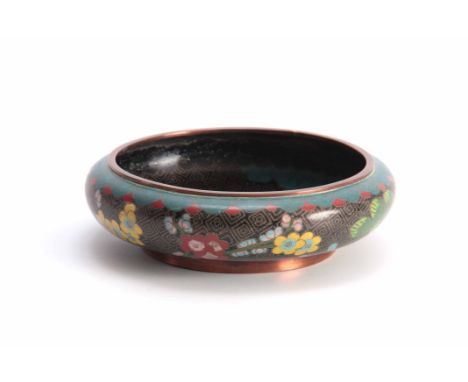 A CHINESE CLOISONNE ENAMEL SHALLOW FOOTED BOWL with overall flower spray decoration on a black and blue geometric ground 20.5