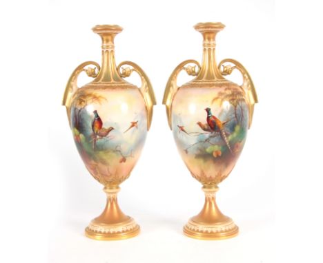 A. LEWIS. A PAIR OF ROYAL WORCESTER VASES of ovoid shape on socle feet with slender gilt necks and scroll handles, the bodies