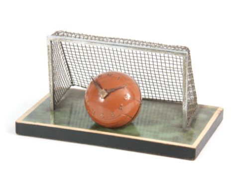 A VINTAGE NOVELTY DESK CLOCK MODELED AS A FOOTBALL with chrome goals and simulated grass plinth 22cm wide, the removable ball