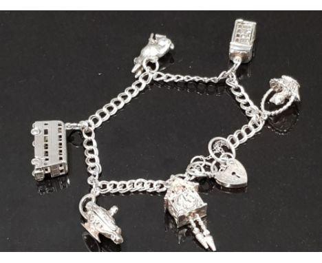 HALLMARKED SILVER CHARM BRACELET WITH 7 CHARMS, TELEPHONE BOX, DOUBLE DECKER BUS, LOVE HEART LOCK AND CUCKOO CLOCK ETC 25.5G