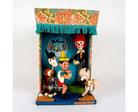 Wooden construction, with printed cotton drapery and maker's nameplate, fitted an electric motor controlling five puppets, in