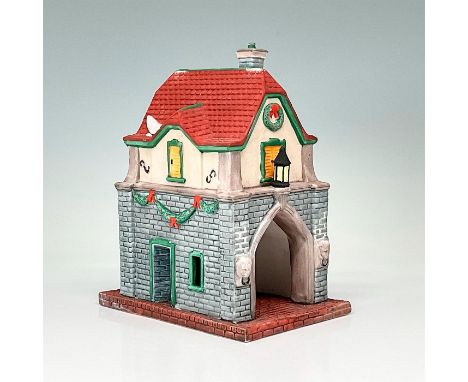 This figure depicts a two story brick and mortar gatehouse. Decorated with winter decor. This item has its original box. The 