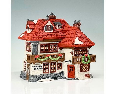 This figure depicts a village building made of red brick and gray stone decorated for the holiday season. This item has its o