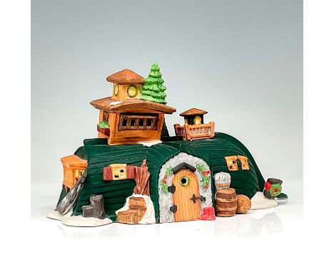 This figure shows a now upside-down boat being used as a village cottage. The cottage is dark green with winter decor. This i