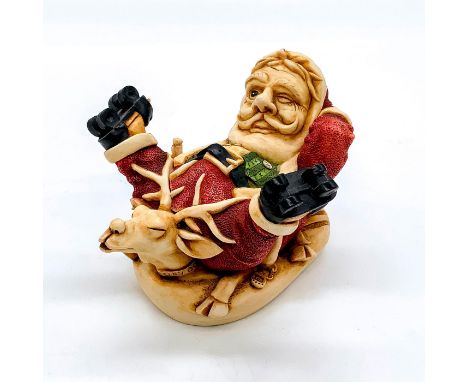 Depicts Santa Claus in roller skates, holding a bottle, and lying atop his squished reindeer. Harmony Kingdom backstamp. This