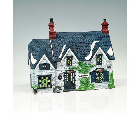This figure depicts a quaint village style home made of light and dark blue brick with snow on the roof. This item has its or