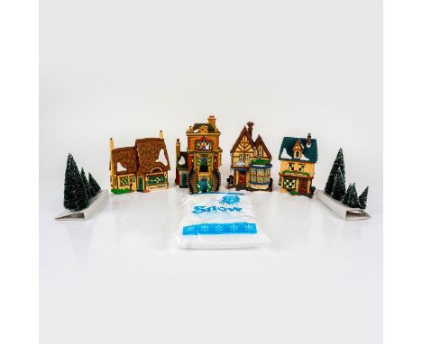 This figure is a set of lovely cream colored village cottages. There are four cottages, and multiple pine trees covered in sn