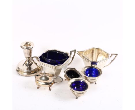 A silver4-piece cruet set with blue glass liners, a silver squat candlestick, and a silver plated milk jug and sugar bowl (7)