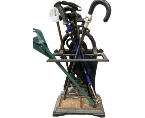 A Victorian cast iron stick stand, together with an assortment of shooting sticks, a walking 'seat' and other sticks (a lot)