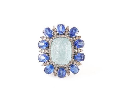 AN AQUAMARINE, KYANITE AND DIAMOND DRESS RING, BOXEDWith central carved floral motif aquamarine, with a surround of oval cut 