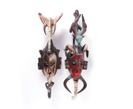 TWO AFRICAN TRIBAL PAINTED WOODEN MASKS (2)Probably 20th Century, Guro Tribe, Ivory Coast The first with red painted face, su