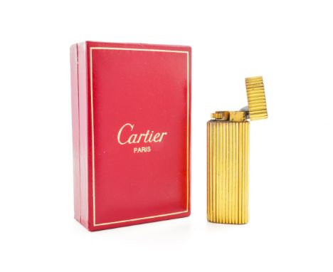 A GOLD PLATED CARTIER GAS LIGHTEROf rounded rectangular form, with ridged decoration with a Cartier Paris case