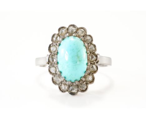 A TURQUOISE AND DIAMOND OVAL CLUSTER RINGClaw set with the oval turquoise within a surround of rose cut diamonds, ring size N