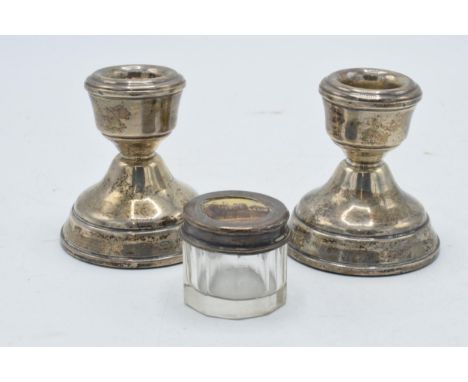A pair of short silver candlesticks, Birmingham 1974, 7cm tall, together with a silver topped glass jar (3).  