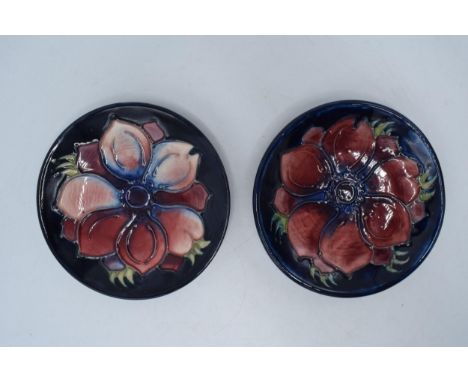 A pair of Moorcroft floral pin dishes (2), 12cm diameter, one with silver line.  In good condition with no obvious damage or 