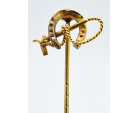 9ct gold stick pin in the form of a riding crop and horseshoe, 1.3 grams, 5cm long.  