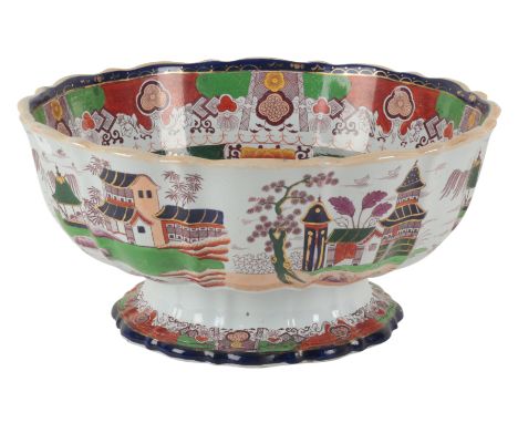 A LARGE VICTORIAN REAL STONE CHINA BOWL the scalloped basin decorated with pagodas in mountainous landscapes, on a stepped fo