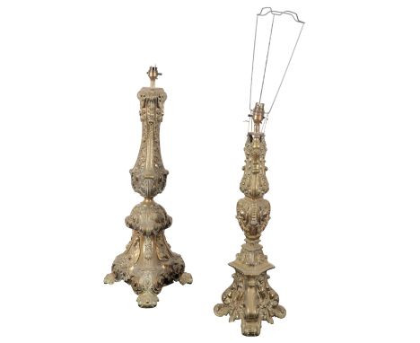 TWO SIMILAR CONTINENTAL BRASS ALTAR LAMPS both of tripod form, decorated to the base with figural representations of religiou