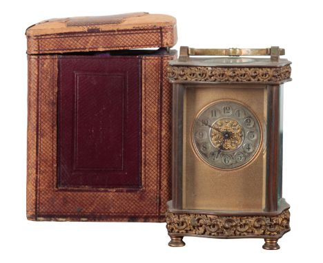 A BRASS CARRIAGE CLOCK with silvered chapter tings and Arabic numerals, with c-scroll embossed frieze to the top and bottom o
