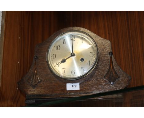 A MANTEL CLOCK WITH CARVED DETAIL
