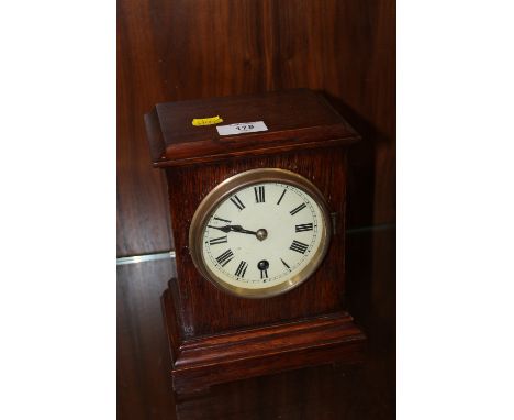 AN OAK MANTEL CLOCK WITH KEY