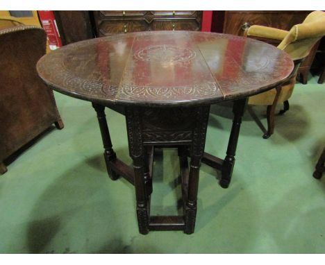 A 19th Century carved oak drop leaf table on carved legs with rose. Opening measurements 89cm wide 75cm deep and 71cm high