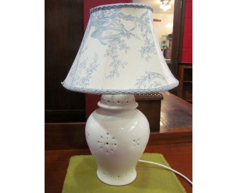 A cream table lamp with pierced detail