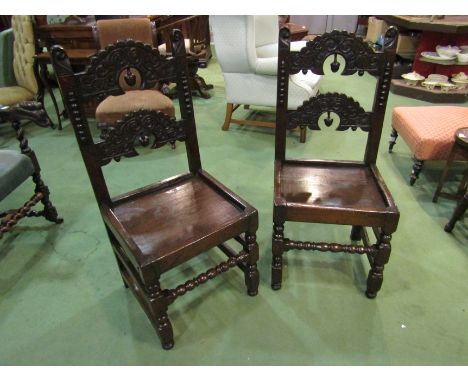 A pair of 18th Century carved oak Derbyshire chairs on turned and square legs joined by stretchers and bobbin turned front st