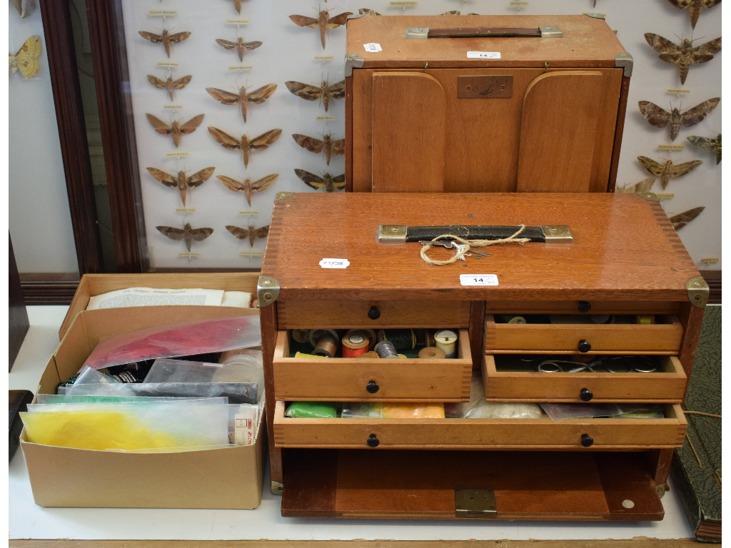 A fly tying box, with a fold down surface, containing assorted hackle