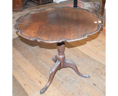 A mahogany tripod table, with a piecrust top, a fluted and reeded vase turned column and leaf carved feed, 82 cm diameter 