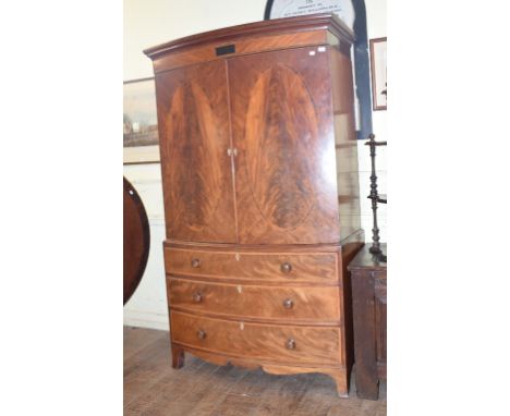 A 19th century bow front mahogany linen press, with inlaid decoration, on shaped bracket feet, 128 cm wide See illustrationRe