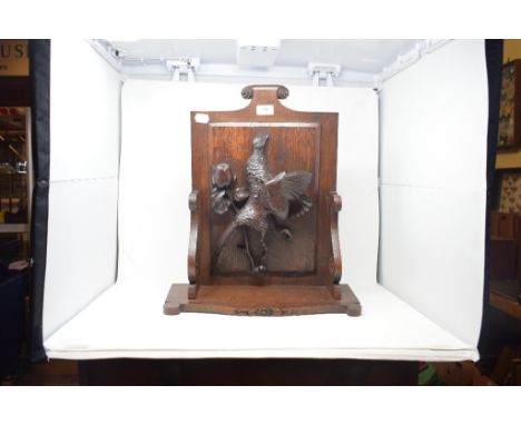 A carved oak wall bracket, decorated a hanging pheasant, 44 cm wide 