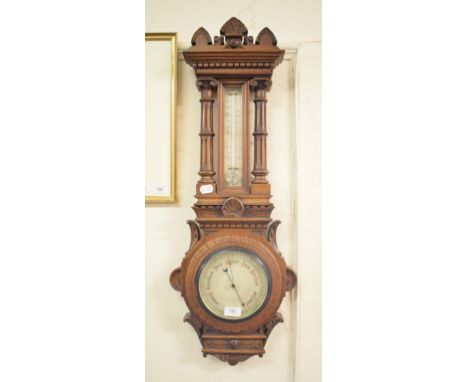 A late Victorian aneroid barometer, with thermometer, in a carved oak case, 85 cm high, and a mantel clock, in a walnut case 