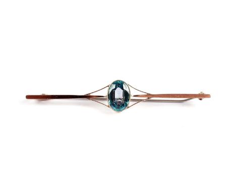 A Garnet Topped Doublet bar brooch, the oval facet cut light blue stone in a 9ct gold mount, 4.7g gross. 