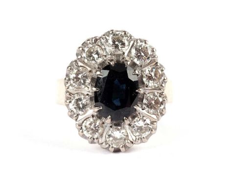 A sapphire and diamond cluster ring, the faceted oval sapphire approximately 6 x 8mm, within a halo of diamonds weighing appr