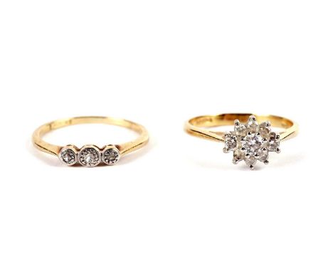 A diamond cluster ring, in 18ct yellow gold, size K, 2.2g gross; and a diamond three stone ring, in platinum and yellow gold,