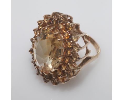 Large and impressive citrine cocktail ring, set with an val mixed cut citrine with two rows of bi-coloured citrines surroundi