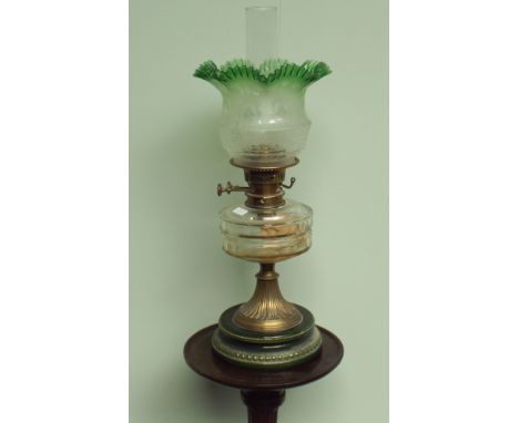 Victorian brass and glass reservoir oil lamp with green patterned shade standing on green china base   Condition - One chip o