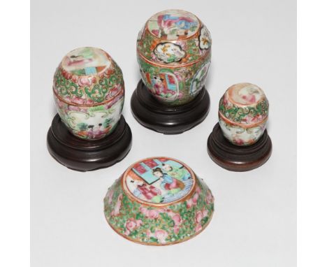Three miniature famille rose porcelain egg shaped trinket boxes, all with hardwood carved stands, largest 6 cms tall.