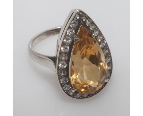 Ladies citrine cocktail ring, set with a tear drop shaped citrine surrounded by white stones, on silver shank. Size J