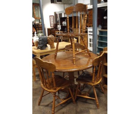 Circular pine kitchen table on tripod foot and set of six flat back kitchen chairs 