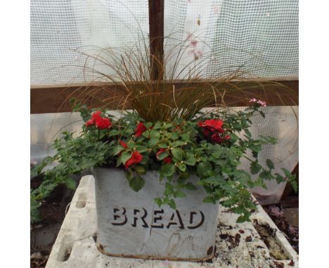 Old enamel bread bin with red and other fillings 