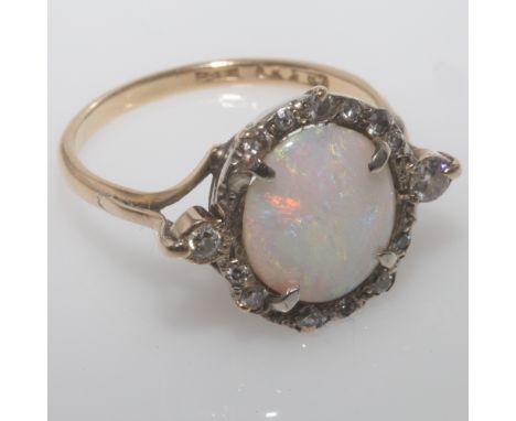 Edwardian opal and diamond ring, set with an oval opal displaying good play of colour, with rose cut diamond border. Shank st