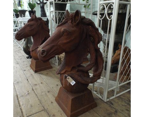 Pair of life sized weathered cast iron Horse head gate post finials.  Horse head mounted on a sphere with square plinth appx 